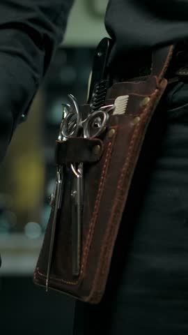 Close-up of a barber glove near tools like a cowboy hand near the gun. Readiness for immediate work concept. Gloves for safety during a COVID-19 pandemic. Small business ready to go. Vertical shot.