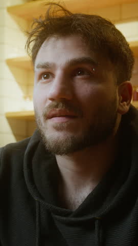 Young Man Holding Smartphone Displaying I Am Not AI Message to Emphasize Human Identity in a Digital World ,vertical video