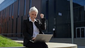 Successful senior woman celebrating achievement on laptop - Powered by Shutterstock - Get 15% off with code: PIKWIZARD15