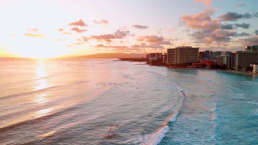 Colorful dramatic horizon at sunset on the Pacific ocean in Waikiki Beach Honolulu Hawaii. Calm water with people swimming and relaxing.