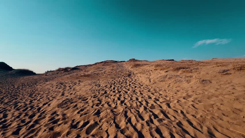 walking through the yellow orange small sand desert under neon sky