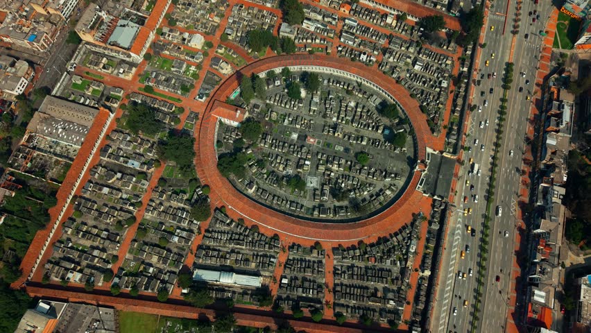 Aerial tops down Bogotá City, central Colombian cemetery graveyards, capital town with daily traffic in nearby avenue