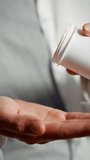Female hands carefully pour out colored capsules into an open palm, preparing for medication administration. This action takes place indoors, emphasizing attention to health - Powered by Shutterstock - Get 15% off with code: PIKWIZARD15
