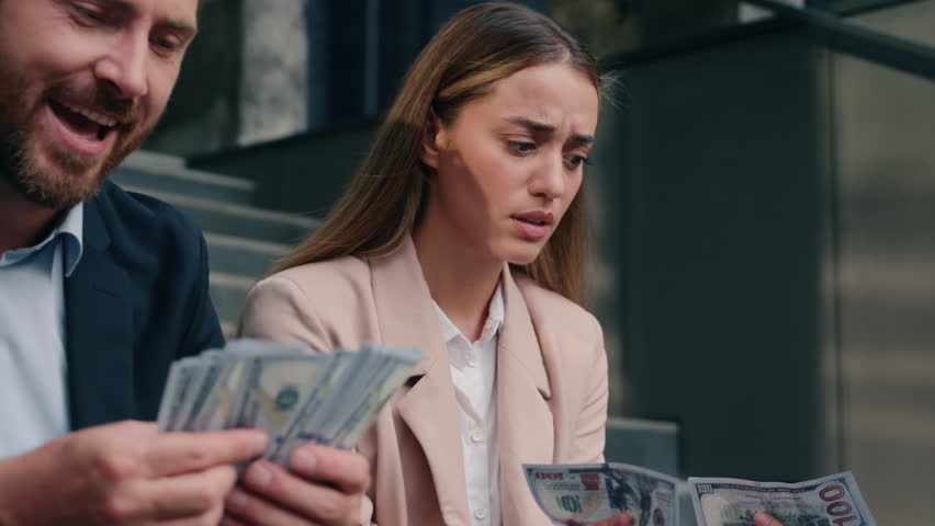 Two business people in city Caucasian happy rich man businessman male masculine counting salary money sad woman female girl businesswoman frustrated with cash financial unequal rights injustice sexism
