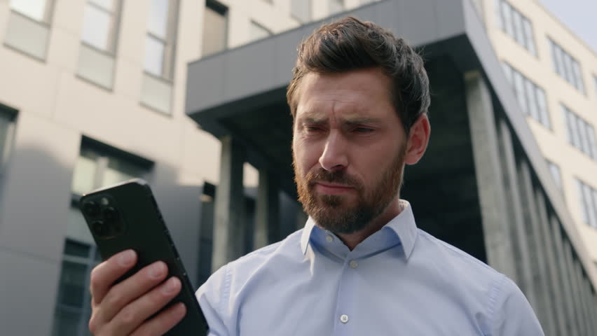 Upset sad failure anxiety male near office read bad news receive message reject bank notification problem lost job failure headache in city Caucasian man business guy businessman using mobile phone