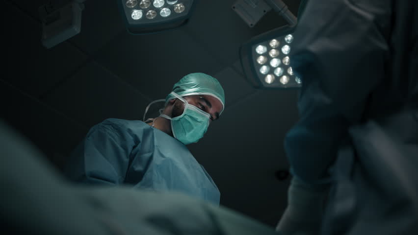 Low angle shot of a Surgeon Performing Operation Under Bright Surgical Lights in Modern Hospital - Powered by Shutterstock - Get 15% off with code: PIKWIZARD15