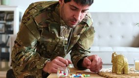 Young veteran in military uniform taking several pills from a glass jar and counting them, suffering from post-traumatic stress disorder at home - Powered by Shutterstock - Get 15% off with code: PIKWIZARD15
