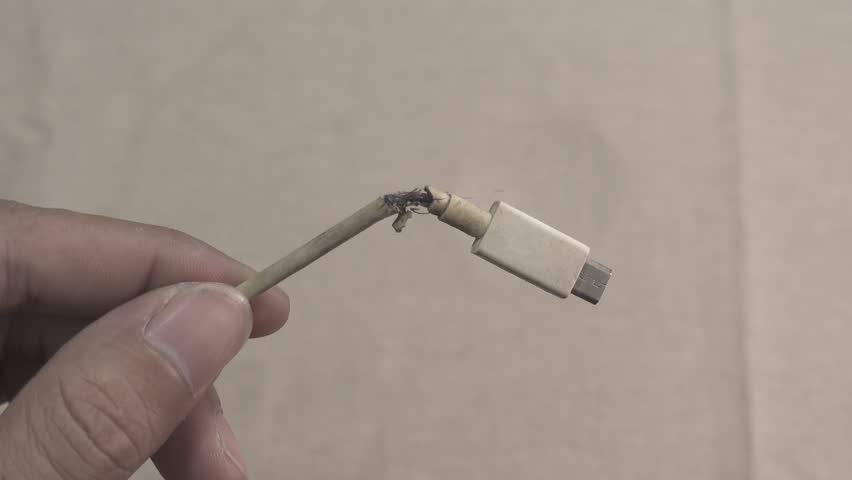 Torn damaged USB cable. The connecting accessory of the smartphone and charging is broken