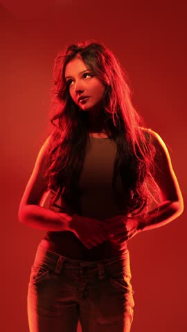 Young girl posing in red light, play of light and shadow