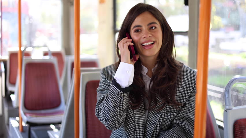 Woman talking on her phone during a bus ride through the city
