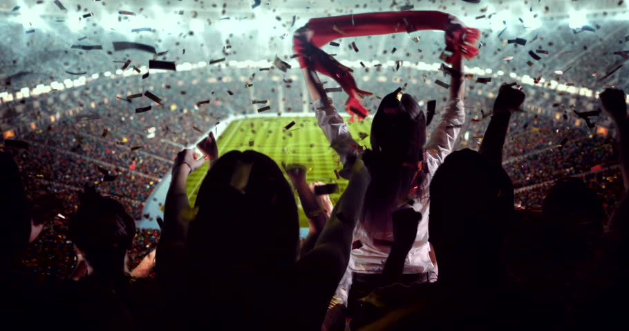 4K video of a lively stadium crowd at a nighttime soccer game, cheering confetti under bright stadium lights