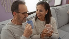 Middle-aged hispanic couple enjoying coffee together in a cozy living room, showcasing love and togetherness with a warm and intimate atmosphere indoors. - Powered by Shutterstock - Get 15% off with code: PIKWIZARD15