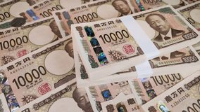 Many 10,000 yen bills and stacks of bills rotating. Translation: 10,000 yen, Bank of Japan note, Bank of Japan, produced by the National Printing Bureau, Eiichi Shibusawa 10,000 yen notes. - Powered by Shutterstock - Get 15% off with code: PIKWIZARD15