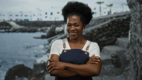 Woman wearing apron standing confidently by the seaside, with ocean waves and rocky landscape in the background, embodying tranquility and a love for nature. - Powered by Shutterstock - Get 15% off with code: PIKWIZARD15