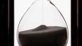 macro of sand grains particles running inside hourglass measuring passing time in countdown to deadline on white background - Powered by Shutterstock - Get 15% off with code: PIKWIZARD15