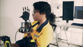 Asian female engineer examining robotic hand in high-tech lab. Focus on technology, robotics, STEM, innovation, and women in engineering fields. - Powered by Shutterstock - Get 15% off with code: PIKWIZARD15