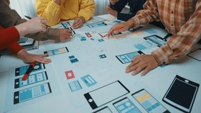 A dynamic team collaborates on user interface design, engaging with colorful sketches and digital prototypes in a modern workspace, fostering creativity and innovation. SACTR - Powered by Shutterstock - Get 15% off with code: PIKWIZARD15