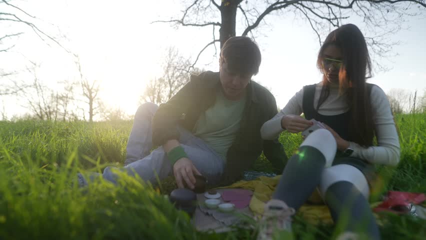 A Young Couple is Enjoying a Beautiful and Relaxing Picnic Together in the Great Outdoors of Nature