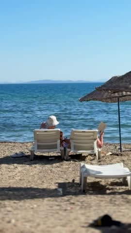 Beach, An elderly couple sunbathing and reading on the beach