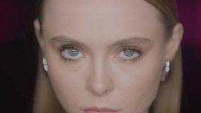 Close-up of a young woman making direct, intense eye contact with the camera in a studio setting. Stylish look, professional lighting, and a captivating expression. - Powered by Shutterstock - Get 15% off with code: PIKWIZARD15