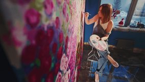 Professional female artist creating vibrant, large scale floral mural, painting colorful abstract design on studio wall with passionate artistic approach - Powered by Shutterstock - Get 15% off with code: PIKWIZARD15