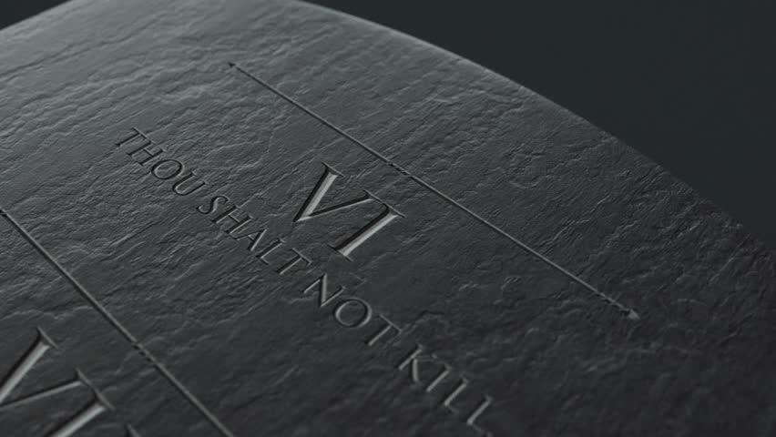A slow close up pan across a stone tablet with the second five of the ten commandments inscribed onto them