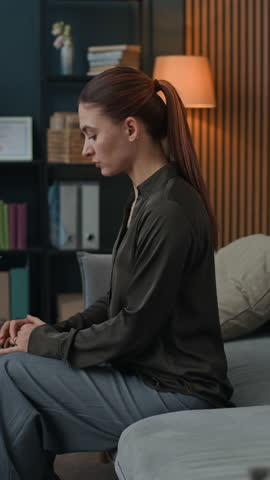 Vertical shot of female African American counselor communicating with young woman during therapy session