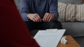Tilt up slowmo shot of middle-aged Caucasian man breaking pencil while having therapy session with counselor - Powered by Shutterstock - Get 15% off with code: PIKWIZARD15