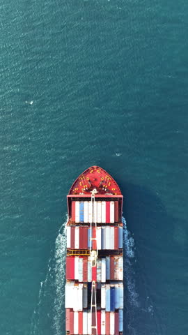Vertical. Aerial view of container cargo ship in sea.