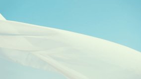White translucent fabric gently waves in the wind against a clear blue sky. Soft, airy textures dance in slow motion, creating a calm, dreamy, and ethereal visual of freedom and serenity. - Powered by Shutterstock - Get 15% off with code: PIKWIZARD15