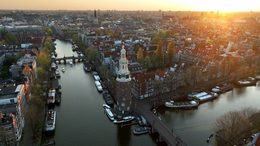 Amsterdam aerial view at sunset with canals, boats and a bell tower, historic Dutch city of Amsterdam, capital of the Netherlands