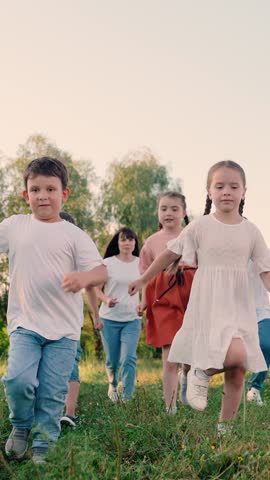 Children, parents run in park, friends play in summer. Concept of happy childhood dream. Happy boy girl run, play together, nature. Family mom dad kids, weekend outdoors. Kids run, active lifestyle