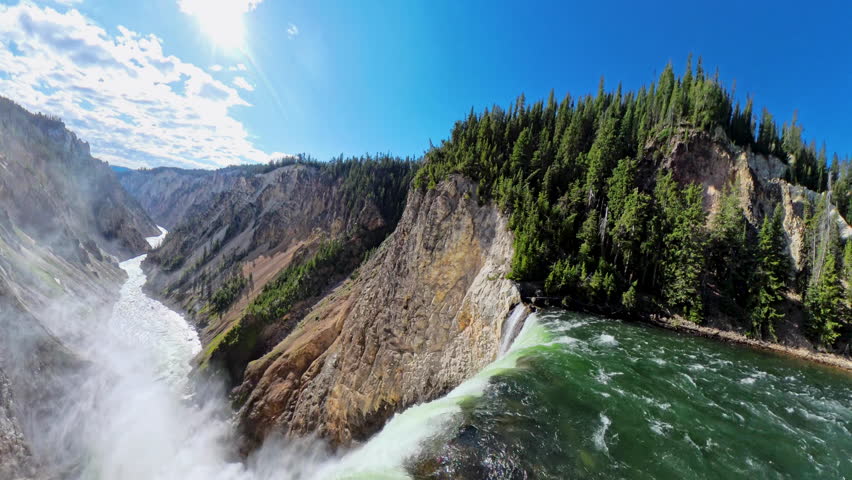 Water Cascades into Steamy Canyon in Yellowstone National Park