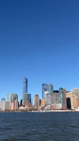 POV (point of view) of the downtown New York City (Manhattan, NYC, New York, United States) skyline on a clear day, taken from a boat in vertical video 9:16.