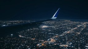 A breathtaking view from an airplane window at night, featuring the vibrant and bright city lights below as the plane begins its descent - Powered by Shutterstock - Get 15% off with code: PIKWIZARD15