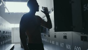 Silhouette of a man drinking water from a bottle in a gym. Concept of hydration, fitness, and post-workout refreshment. Man Drinking Water in Gym After Workout for Hydration and Refreshment - Powered by Shutterstock - Get 15% off with code: PIKWIZARD15