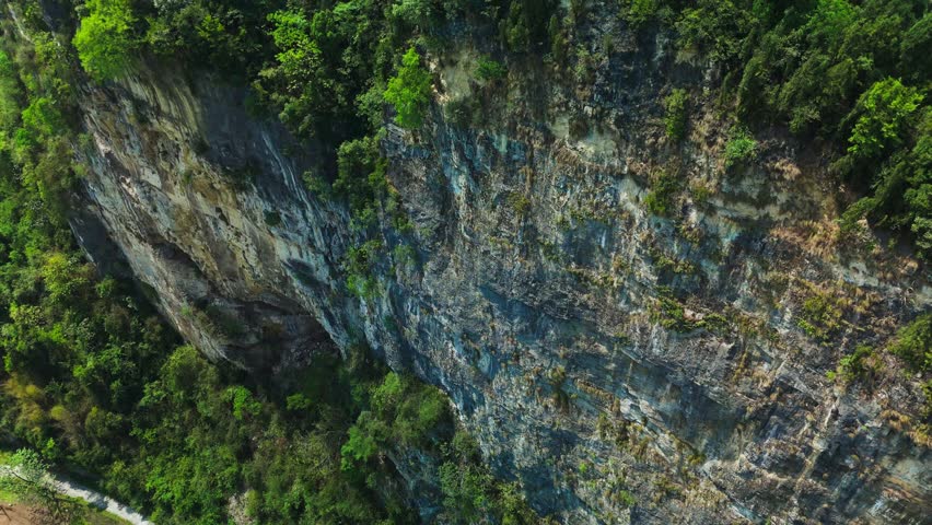 The karst landscape is characterized by dramatic conical hills, towering limestone pinnacles, deep sinkholes, and intricate cave systems, shaped over millennia by the dissolution of soluble bedrock.