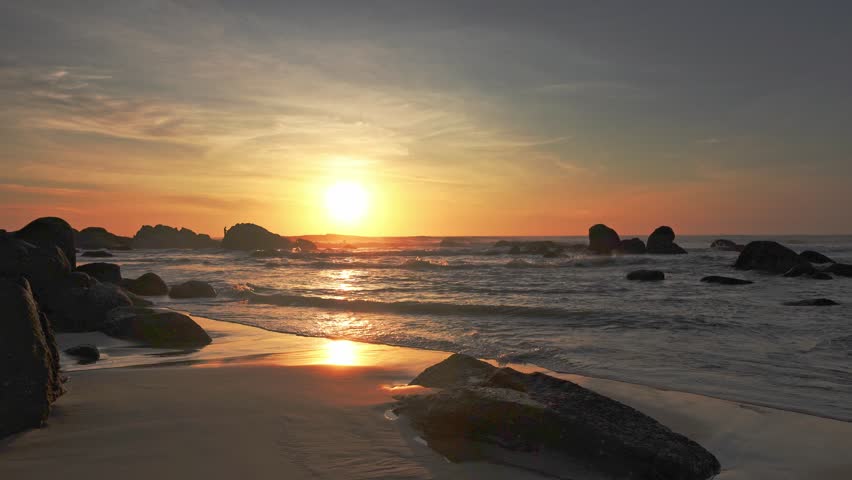 Beautiful sunrise dawn beach with waves, sand, sunrise sky gradually rising to the horizon. Seascape to relax the soul