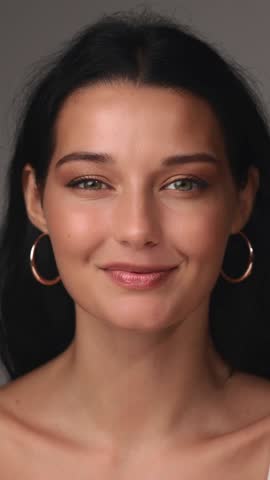A cheerful Latina woman with a radiant smile holds two makeup brushes, highlighting beauty and cosmetics. Ideal for makeup tutorials, skincare, beauty products, and self-care branding.