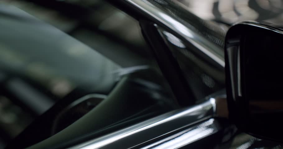 This image features a detailed close-up of a glossy car side mirror, highlighting the sleek, modern design and reflective surfaces of contemporary automotive style.