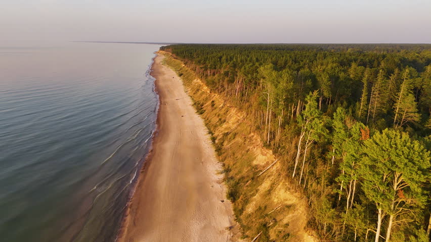 Sweeping view of Latvian coastline with bluff edge and golden terrain in soft light