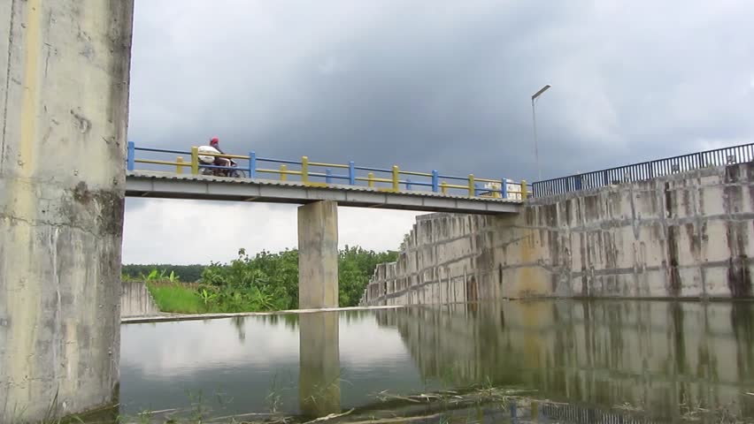 Motorbikes passing by the Klopodhuwur dam bridge, Central Java, Indonesia