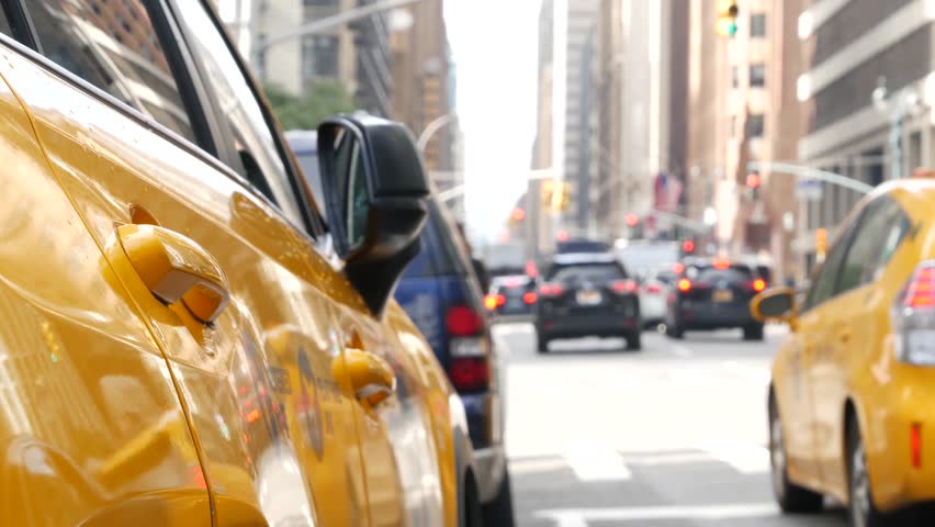 New York City. Yellow taxi car on Manhattan street. Taxi cab on Midtown Lexington avenue. Medallion taxicab rear view on Lex ave waiting for people or passengers on road. Urban scene in United States.