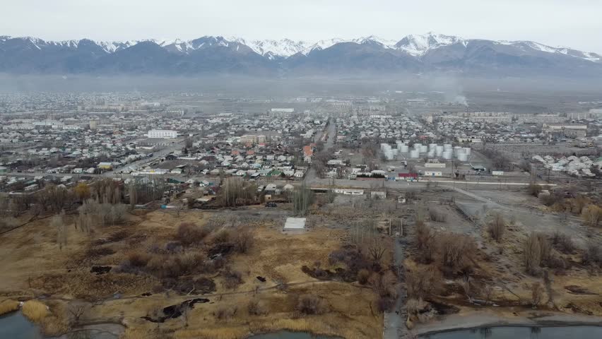 CITY NEAR THE LAKE WITH MOUNTAINS IN THE BACKGROUND