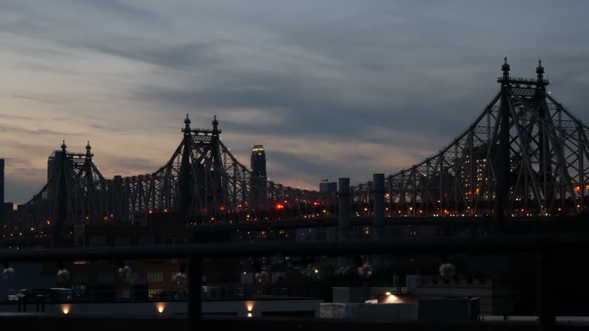New York City Manhattan skyline cityscape. Silhouette of Queensboro Bridge from Queens to Midtown. Rooftop sunset sky from roof in Long Island, United States. NYC architecture, Twilight dusk evening.