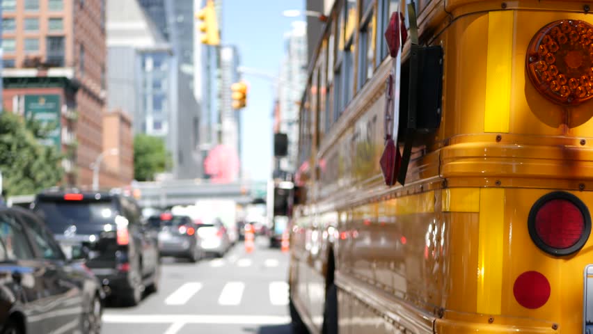 Yellow School Bus on New York Manhattan street, schoolbus truck on busy city road. Children education and transportation, USA. American school shuttle in traffic jam, 10 avenue Chelsea, United States.