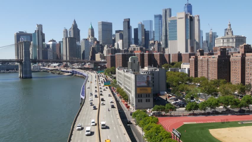 Brooklyn Bridge from Manhattan Bridge. New York City downtown skyline, financial district cityscape, World Trade Center. Transport traffic on FDR Drive highway by East River water, United States.