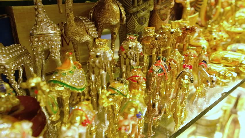 Rows of golden camels, scarab beetles and other trinkets on shelf of souvenir shop. Traditional egyptian souvenirs