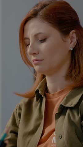 Vertical Screen: While working at her home office, a woman experiences discomfort and stretches to alleviate back pain and numbness caused by long hours of sitting.