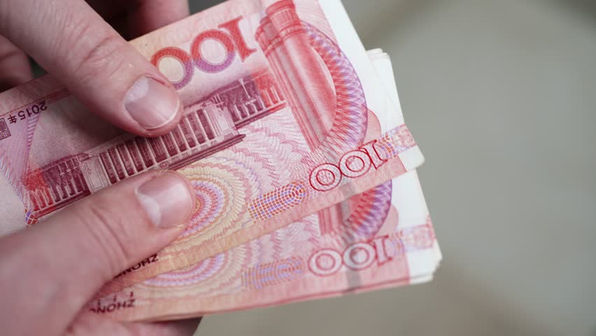 Businessman carefully counting chinese one hundred yuan banknotes, demonstrating financial expertise and meticulous attention to monetary transactions within global economic landscape